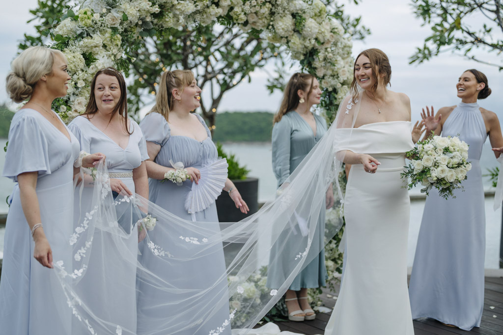 Romantic destination wedding ceremony by the sea with pastel bridal party, heartfelt vows, and joyful confetti celebration in Thailand.